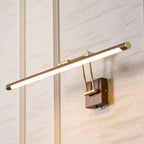 Angled close view of this Clérachic linear wall light lit on a textured plaster wall, with its brass hinge and walnut wall block.