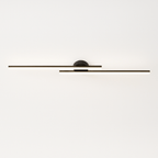 Clérachic black aluminium ceiling light with two offset linear bars and a round canopy, lit with a bright frosted diffuser edge.