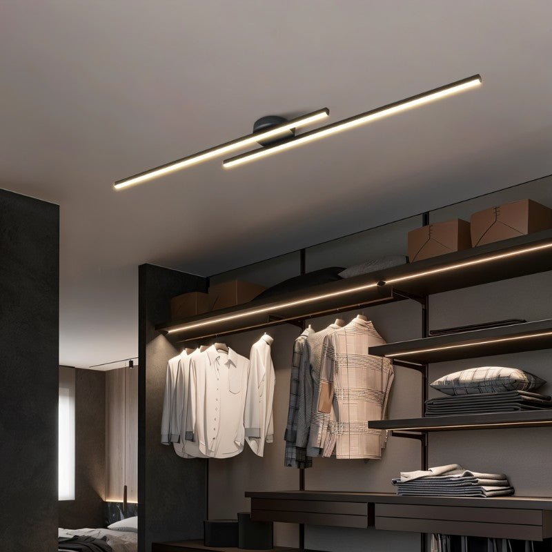 Clérachic black twin-bar ceiling light with frosted diffusers, above an open dressing area with hanging shirts and shelving.