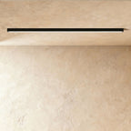 A black linear LED ceiling bar shows its continuous lit strip flush against a plaster ceiling corner, a Clérachic kitchen island light.