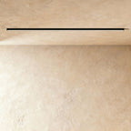 A black linear LED ceiling bar throws a clean lit line onto a warm plaster corner, this Clérachic fixture framed from further back.
