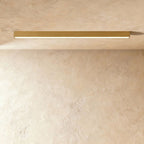 A brushed gold linear LED ceiling bar glows a warm continuous line in a plaster corner, this Clérachic fixture seen from below.
