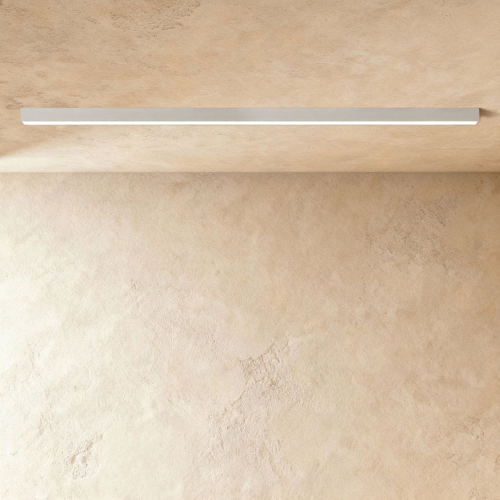 A soft white linear LED ceiling bar shows its lit strip flush against a plaster ceiling corner, a Clérachic kitchen island light.