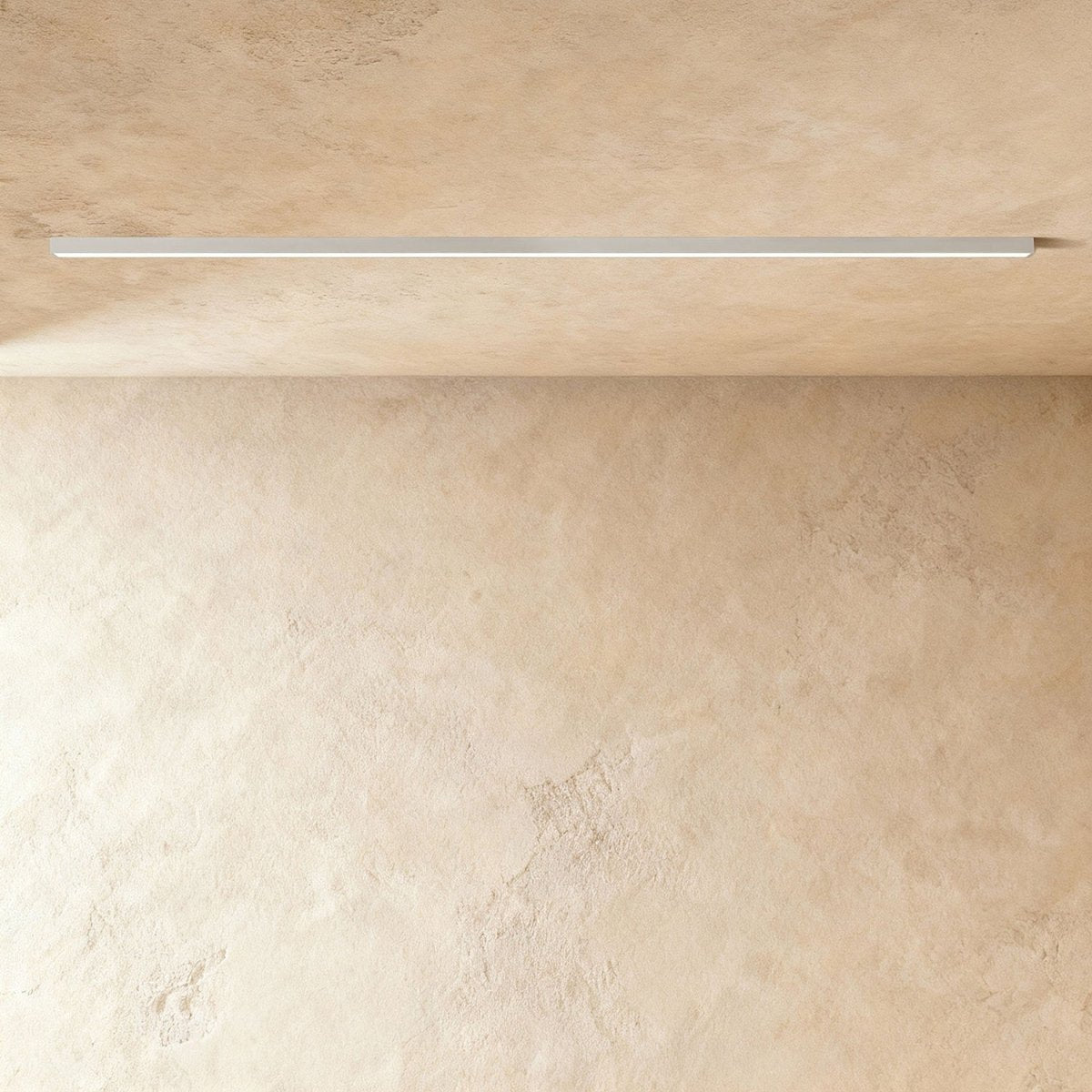 A soft white linear LED ceiling bar throws a clean lit line onto a plaster corner, this Clérachic fixture framed from further back.