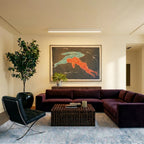 A soft white linear LED bar lights a living room ceiling above a velvet sectional and framed artwork, this Clérachic fixture set flush.