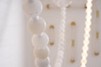 Two illuminated strands of the Clérachic alabaster bead chandelier, light glowing warmly through each stone bead.