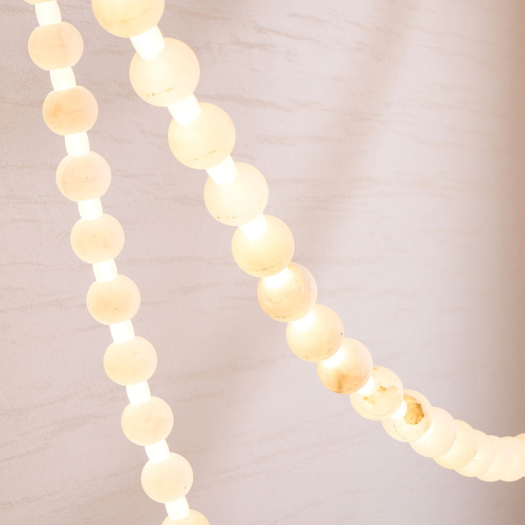 Illuminated alabaster beads of the Clérachic chandelier photographed close, showing the warm glow between each stone.