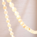 Illuminated alabaster beads of the Clérachic chandelier photographed close, showing the warm glow between each stone.