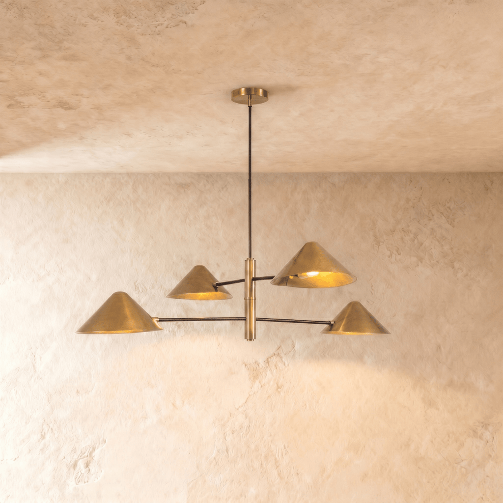 Clérachic linear chandelier in a brighter satin brass, four cone shades branching from crossed arms on the ceiling.