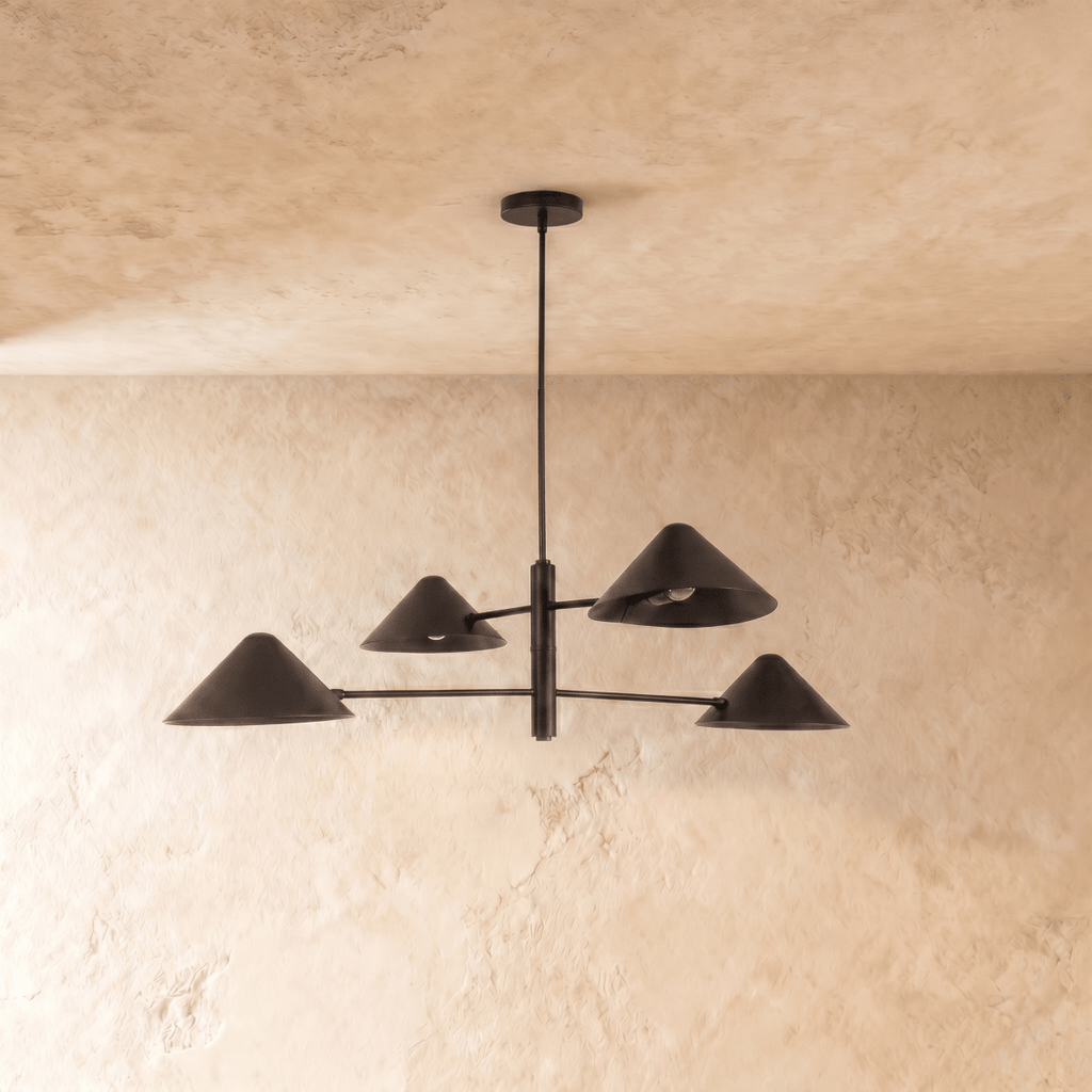Clérachic four-arm linear chandelier in matte black, a closer view of the crossed arms and cone shades overhead.