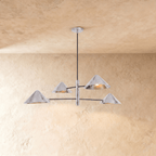 Clérachic linear chandelier in polished chrome, four cone shades branching from crossed arms below the ceiling.
