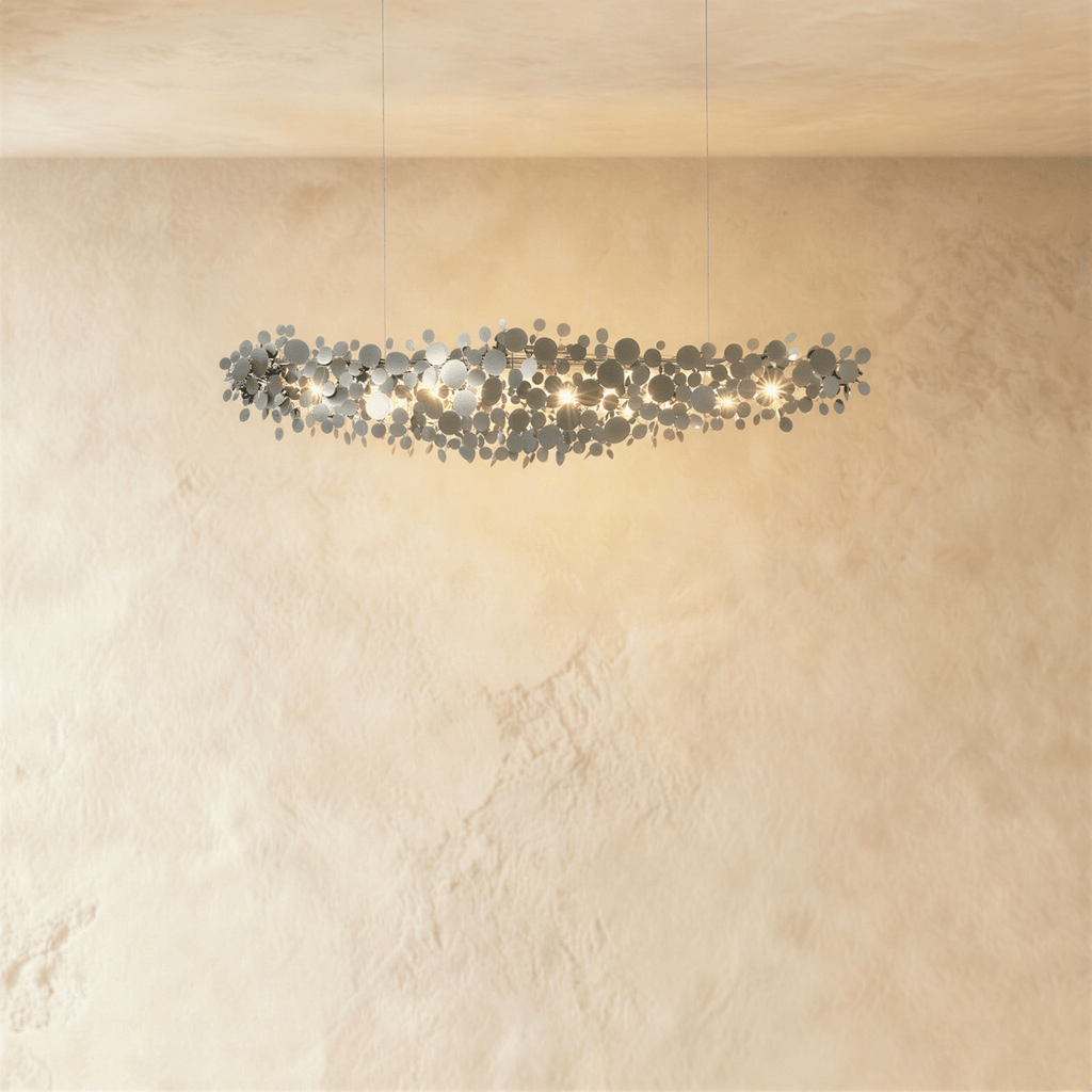 Clérachic compact chrome disc chandelier on two thin cables, glowing against a cream plaster wall.