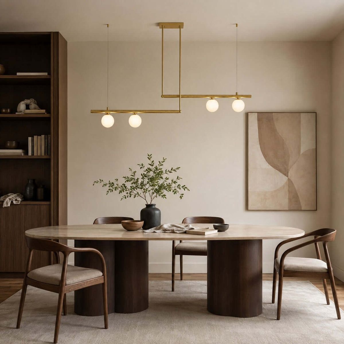 A Clérachic brass chandelier with two offset bars and four lit globes hangs above an oval dining table in a cream room.