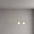 Clérachic chandelier with a single brass bar, two lit frosted globes and an L-shaped drop from a round canopy, on a grey wall.