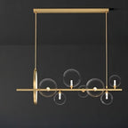 Clérachic gold horizontal chandelier with seven clear glass globes and a gold ring, hung on two rods against a dark backdrop.
