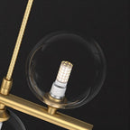 Clérachic close up of a clear glass globe and braided gold suspension cord on the gold bar, with an LED capsule bulb inside.