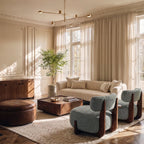 Clérachic six-head gold chandelier with slender arms hung high in a sunlit living room with a cream sofa and panelled walls.