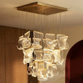 Clérachic rectangular chandelier with rippled translucent panels hung in rows from a slim gold-finish canopy on fine cables.