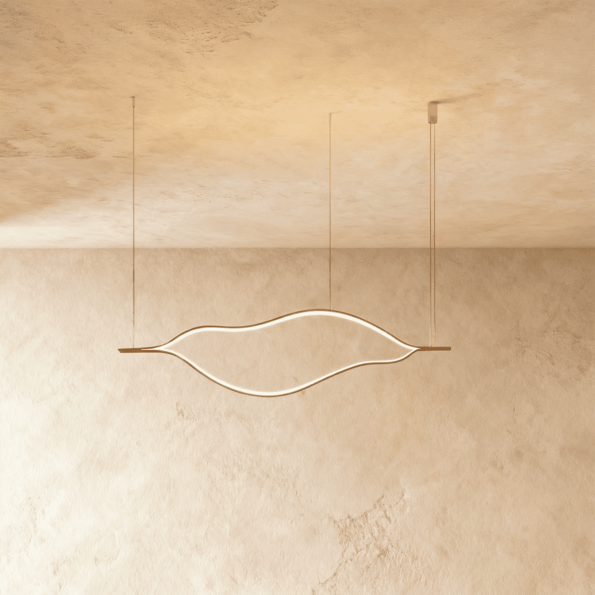 Clérachic flowing gold linear chandelier with a lit LED outline, hung on three fine cables against a textured plaster ceiling.