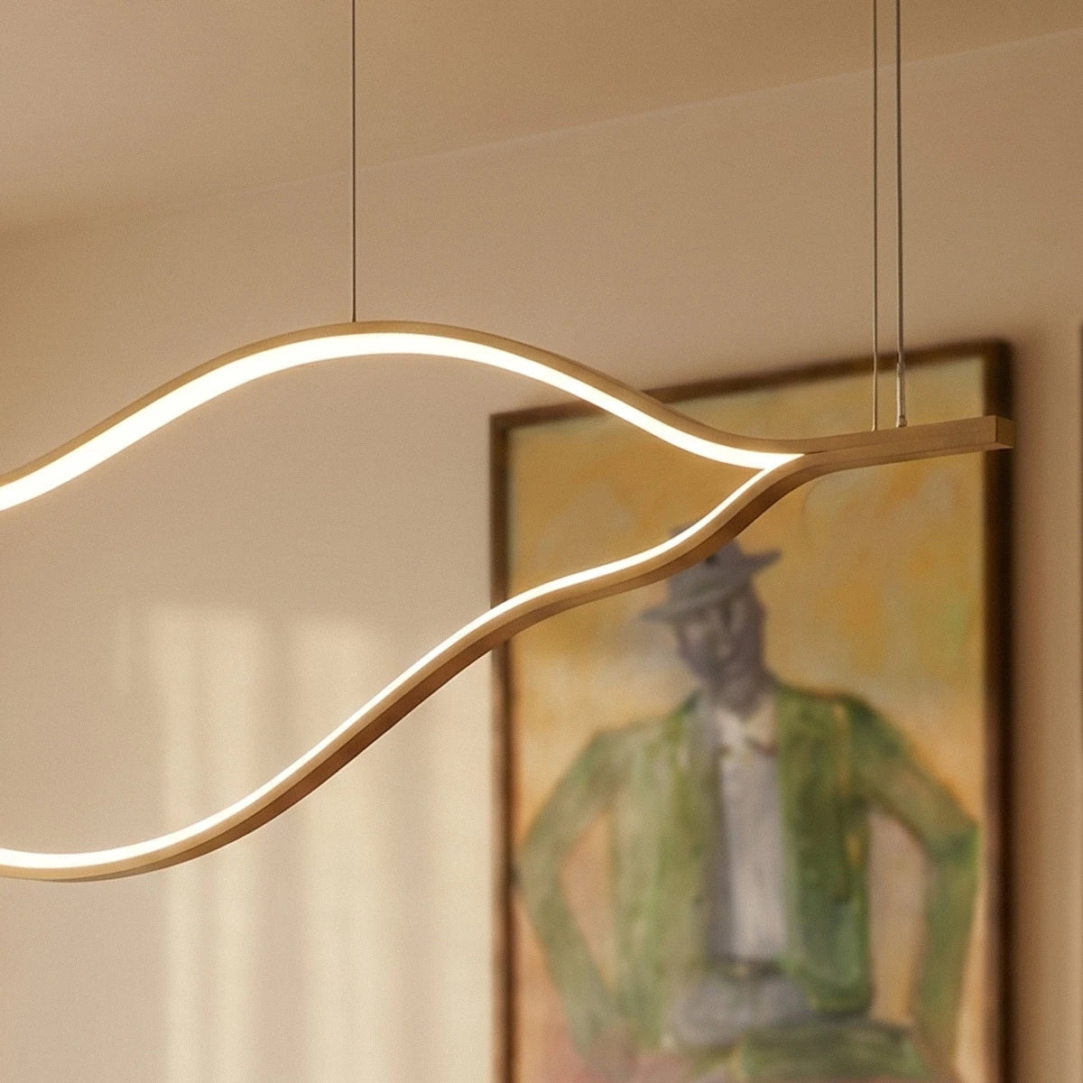 Close crop of the Clérachic gold chandelier end, showing the flat aluminium bar, the two hanging cables and the glowing curved LED line.