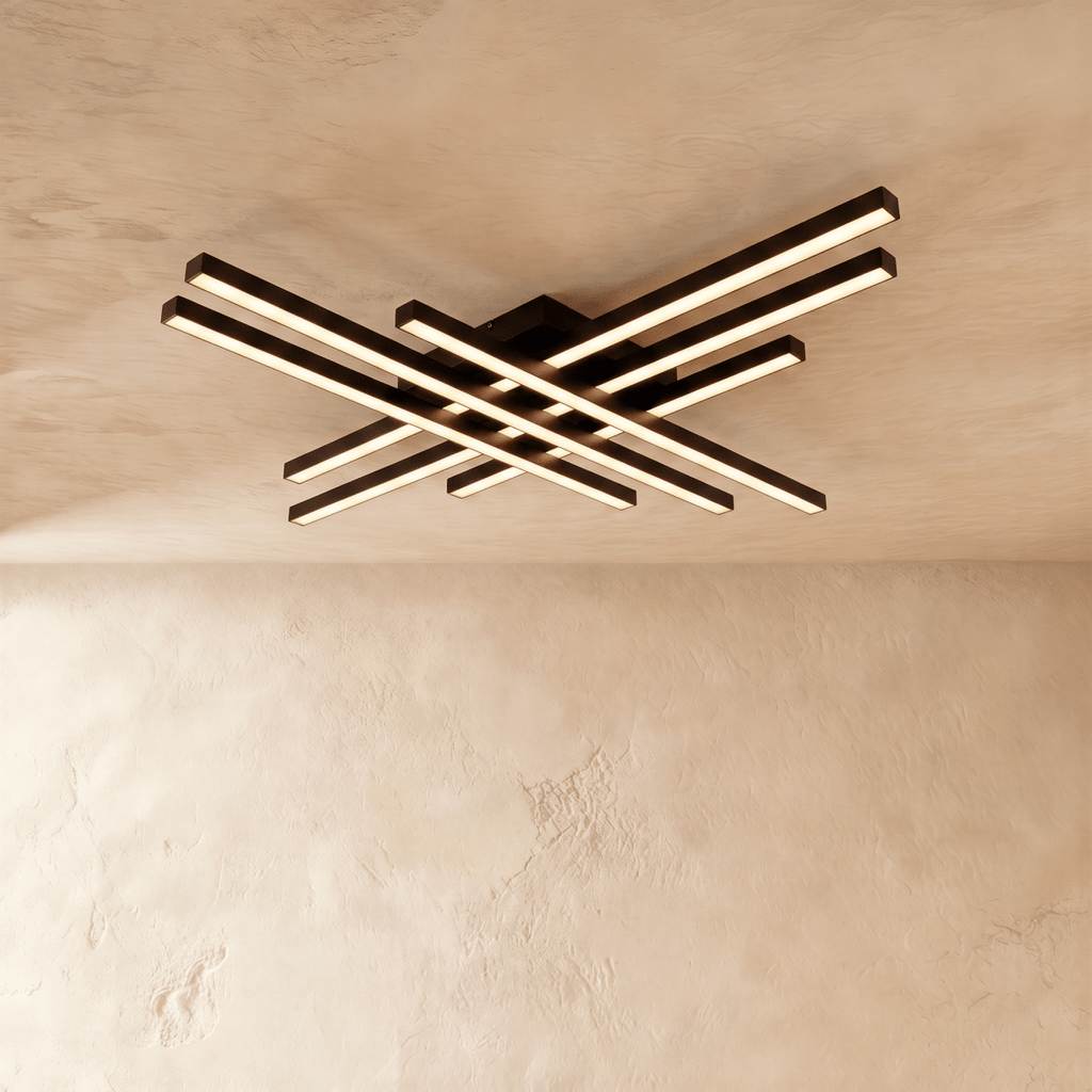 Clérachic wide black six-bar LED ceiling light with frosted diffusers, layered crossed bars lit warm against limewash.