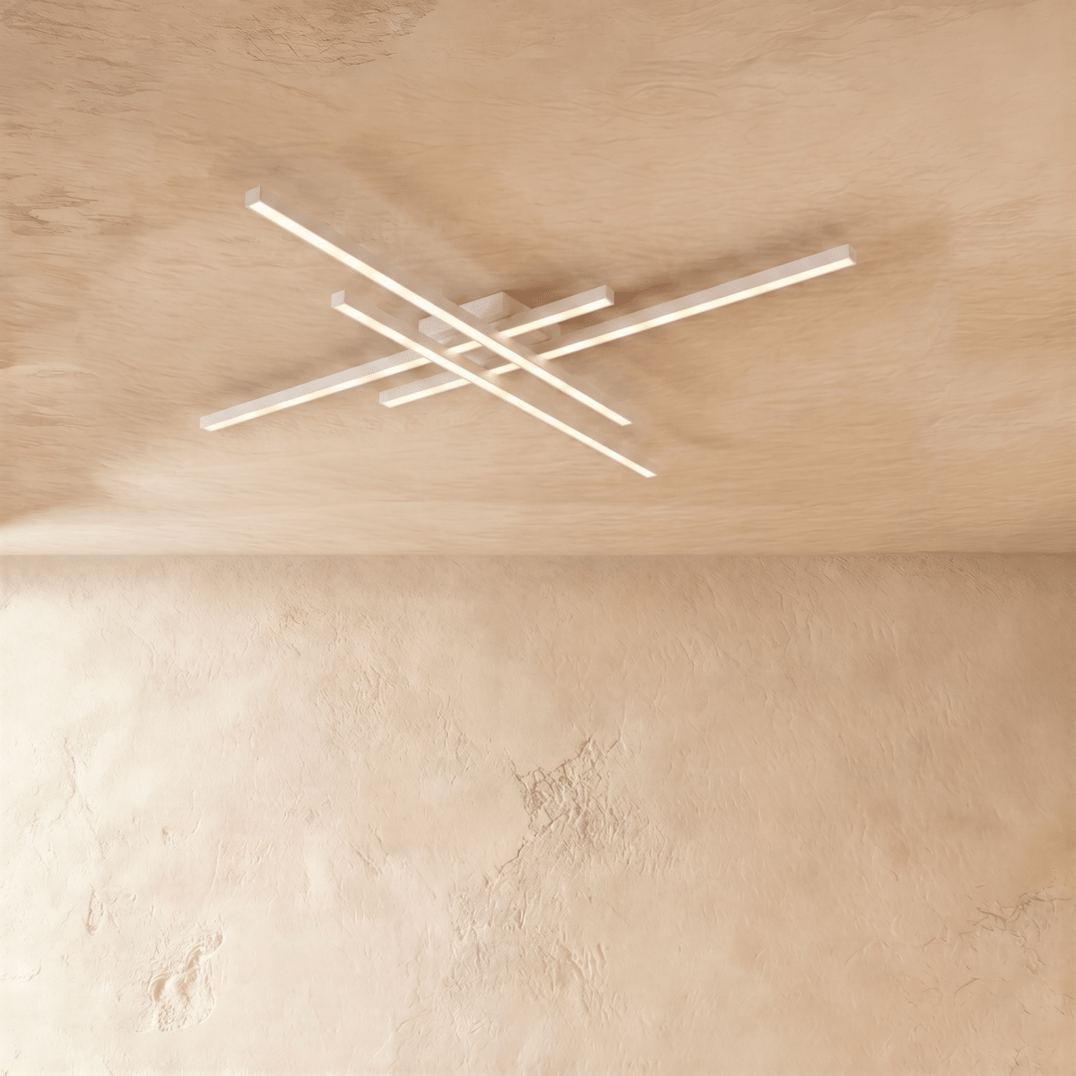 Clérachic white ceiling light of four crossed LED bars, slim aluminium arms glowing soft white on a limewash ceiling.