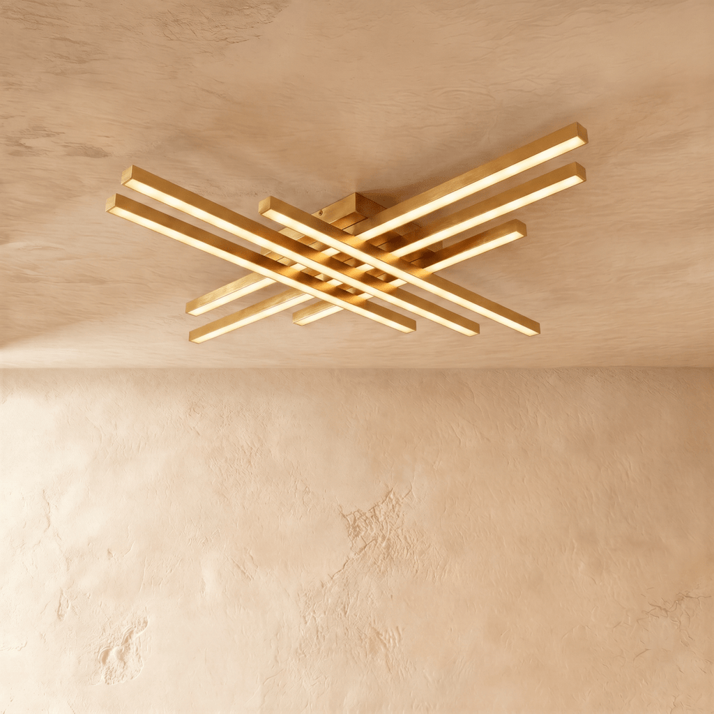 Clérachic wide gold six-bar LED ceiling light, layered brass-toned bars with frosted diffusers lit on limewash.