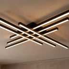 Clérachic black six-bar LED ceiling light close up, layered crossed bars with frosted diffusers lit warm on a ceiling.