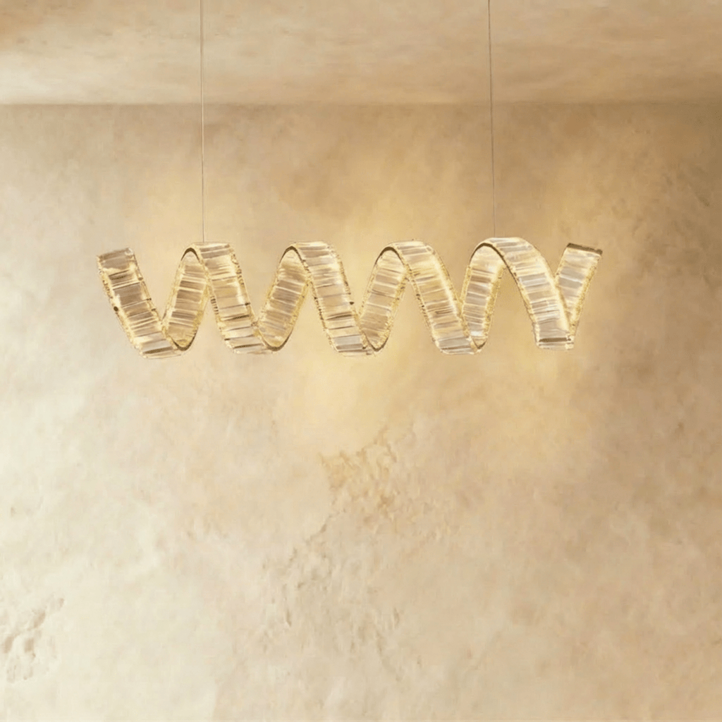 Clérachic single-wave spiral chandelier in gold, with a ribbon of clear crystal blocks glowing warmly on two cables.