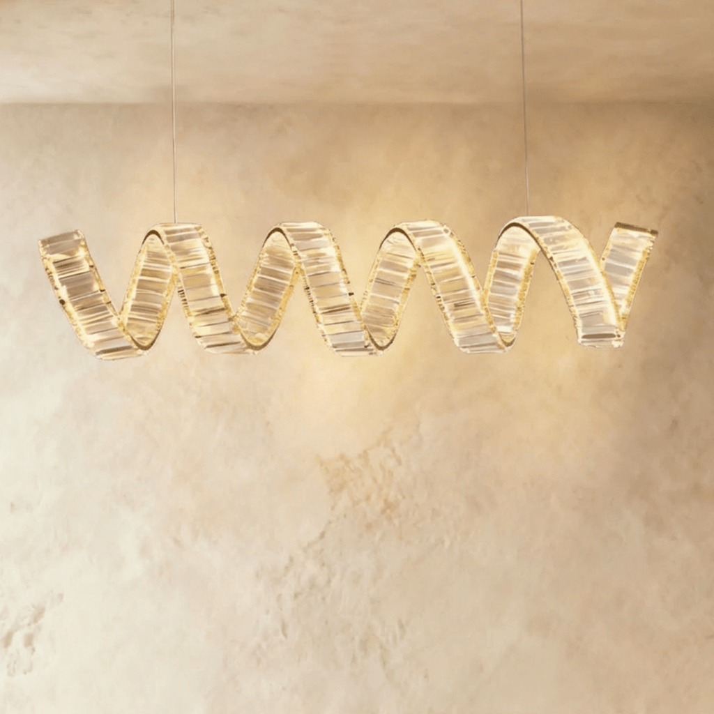 Clérachic longest single-wave spiral chandelier in gold, its crystal ribbon glowing warm under a pale plaster ceiling.