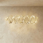 Clérachic wider double-wave spiral chandelier in gold, crystal ribbons twisting together with a soft warm glow.