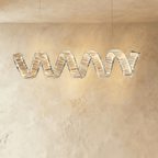 Clérachic single-wave spiral chandelier in chrome, the crystal ribbon edged in polished metal on two cables.