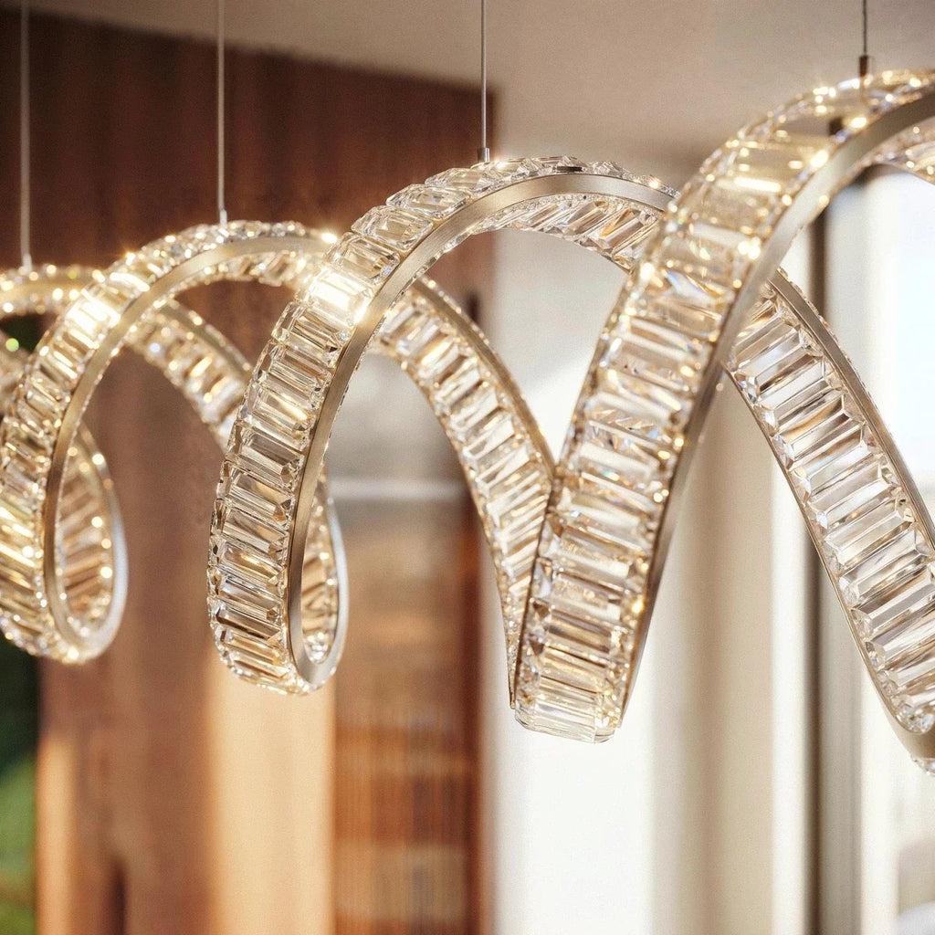 Clérachic close-up of the spiral chandelier's crystal blocks set along a slim metal band, glowing warm.