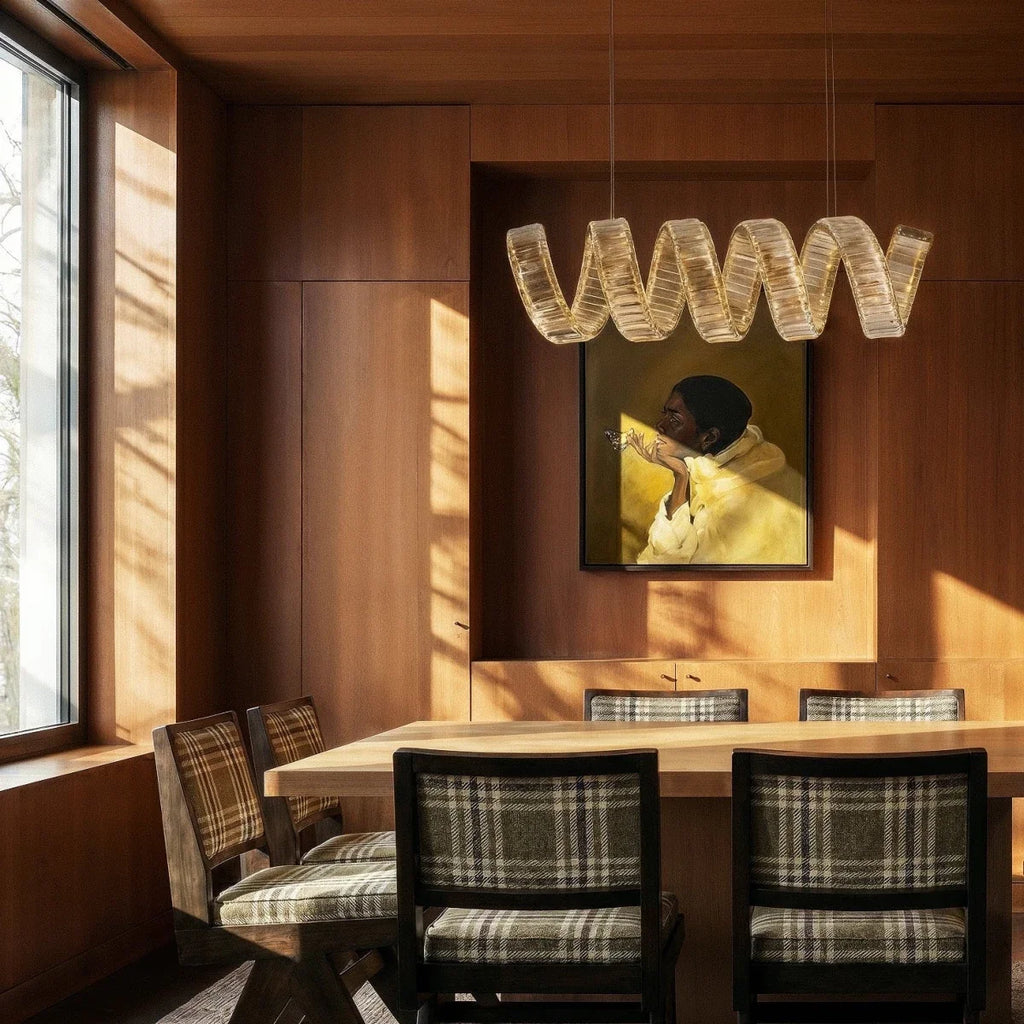 Clérachic single-wave crystal chandelier above a wooden dining table, with plaid chairs in a timber-panelled room.