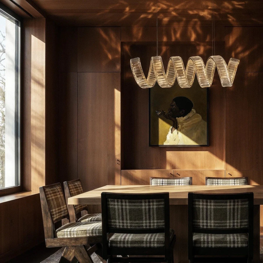 Clérachic single-wave crystal chandelier over a timber dining table, dappled sunlight falling across the panelling.