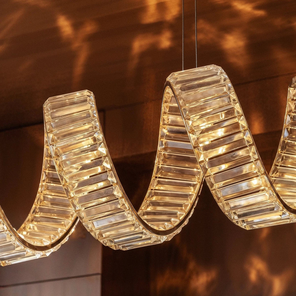 Clérachic close-up of faceted crystal blocks along a looping ribbon, warm light glowing through each facet.