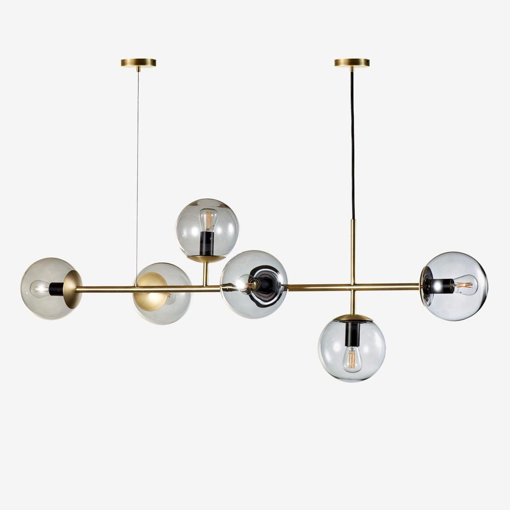 Product shot of this Clérachic pendant on white: six clear glass orbs with visible bulbs along a brass rod and two canopies.