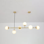 Lit white globes with a soft even glow hang along the brass rod of this Clérachic pendant, below a white ceiling.