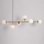 Opal white glass orbs along a brass rod, unlit, on a pale grey backdrop, in this Clérachic pendant with its black cord.