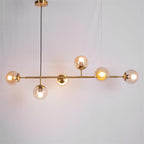 Warm amber light glows from six glass orbs on the brass bar of this Clérachic pendant, shown on a plain grey backdrop.