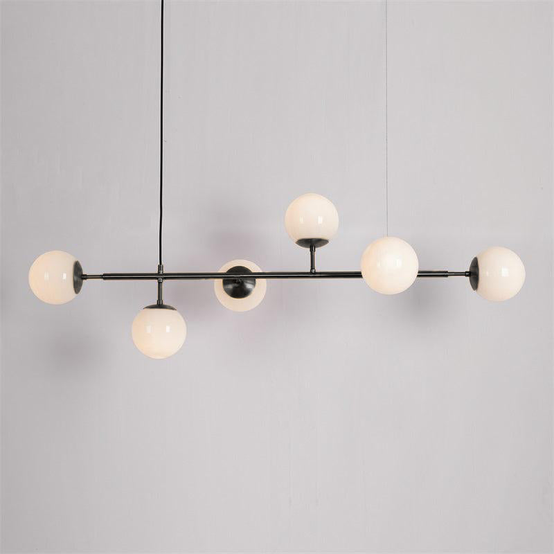 Opal white orbs, unlit, on a slim black bar with a black cord, in this Clérachic pendant against a plain grey backdrop.