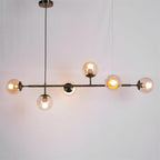 Black bar and amber orbs glowing warm, hung on a black cord in this Clérachic pendant against a plain grey backdrop.
