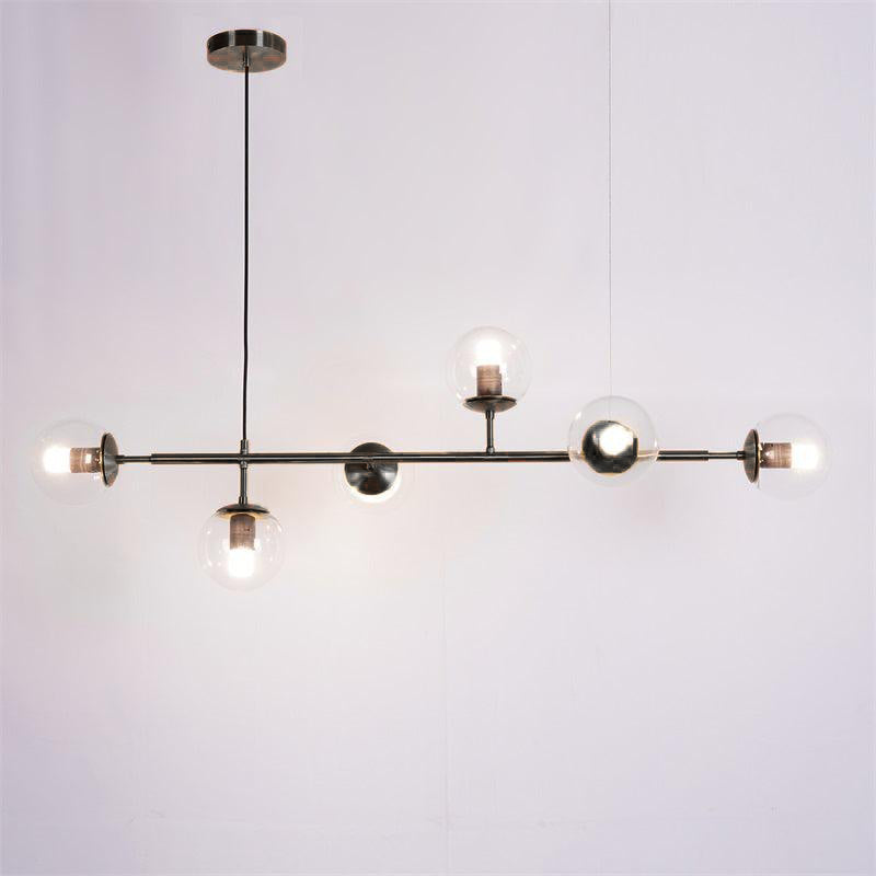Clear glass orbs lit on a black bar with a black canopy, in this Clérachic pendant on a plain grey-lilac backdrop.