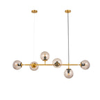 Cut-out view of this Clérachic pendant on white: six amber-tinted orbs on a brass bar, hung from two canopies.