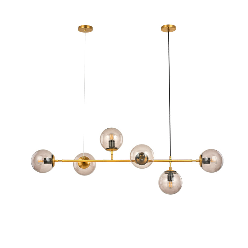 Cut-out view of this Clérachic pendant on white: six amber-tinted orbs on a brass bar, hung from two canopies.