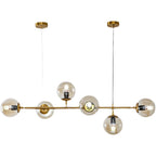 Product shot of this Clérachic pendant on white, with six amber glass orbs and visible bulbs along a brass rod.