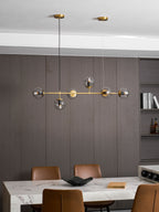 A wider view of this Clérachic pendant hanging in front of grey-brown panelling, above a marble counter with tan leather chairs.
