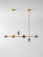 A tall studio view of this Clérachic pendant on light grey, with clear orbs along a brass rod and two ceiling canopies.