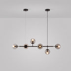 A Clérachic pendant in black, with a black rod and canopies, six clear-tinted orbs lit on a light grey studio backdrop.