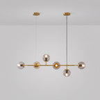 Brass rod, brass canopies and six lit clear orbs, shown on a light grey studio backdrop in this Clérachic pendant.